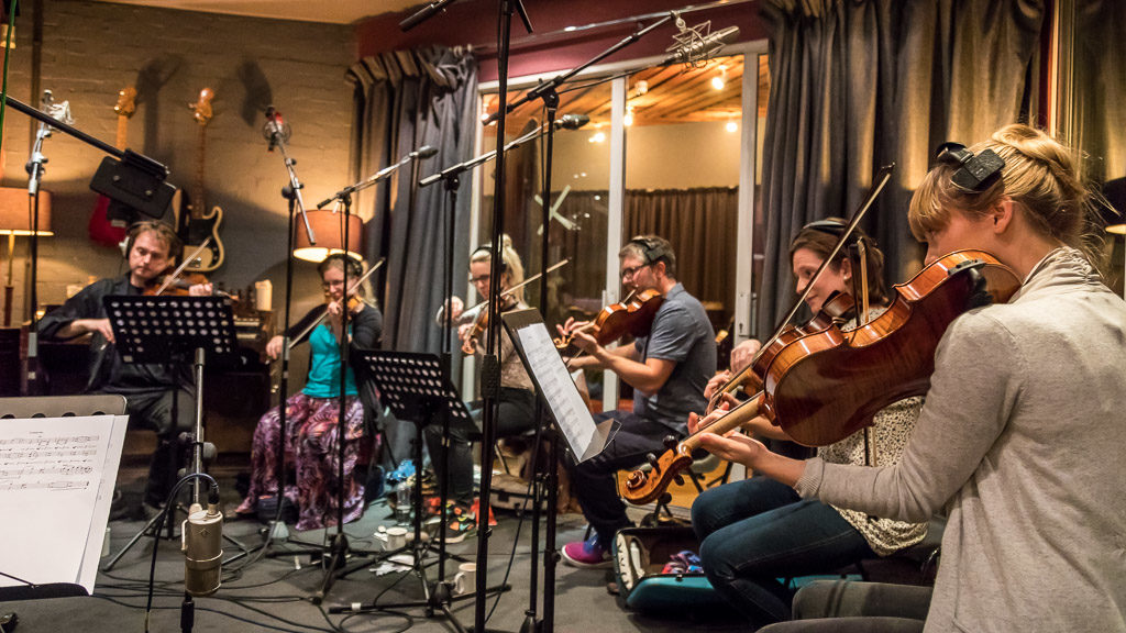 Violinists sight-reading in a recording studio